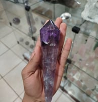 a person holding a large purple crystal point crystal point point point point point point point
