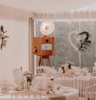 Photobooth en bois clair sur trépied avec éclairage circulaire, modèle Rosa, dans une grande salle