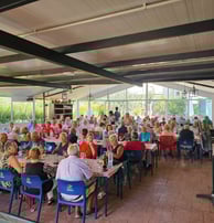 a large group of people sitting at tables in a restaurant