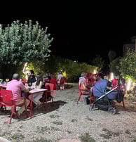a group of people sitting at tables outside