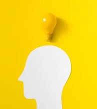 Cabeza diseñada en digital llorando con lagrimas negras y mostrando su cerebro en un fondo amarillo