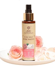 a bottle of pure water with pink roses on a plate