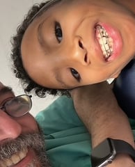a man and a child are smiling and posing for a picture