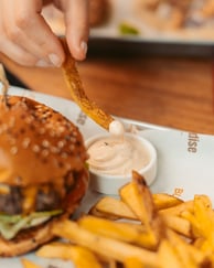 a person is holding a piece of food in front of a hamburger burger king
