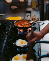 a person cooking food on a stove top
