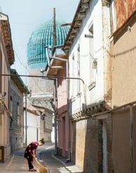 A girl is sweeping a narrow street in Tashkent