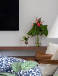 sala de tv com vaso de flores vermelhas