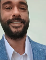 a man with a beard in a suit smilling