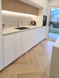 a kitchen with a wooden floor and white cabinets