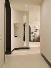 a hallway with a white wall and a black door