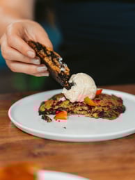 a person is eating a dessert on a plate
