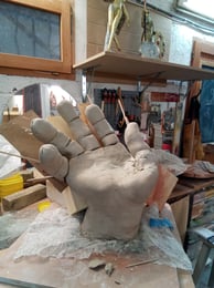 Modelage en cours de la main en argile de Narcisse, sculpture de Lode sculpteure