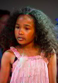 Two children performing in a production of Seussical Jr., with the girl in a pink fringe costume pla