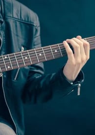 a man in a leather jacket playing guitar