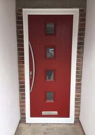 a new red composite front door with 4 squares of glass and curved long handle