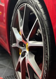 raudonas ferrari automobilis su geltonu ratu ir juoda padanga