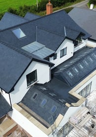 a house with a large roof and a large house with a black roof