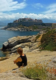 femme assise sur les rochers en corse à calvi