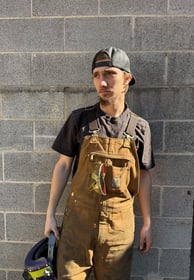 jaspar schirmer standing by a wall in his welding gear