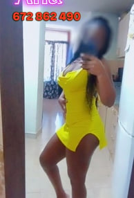 a woman in a yellow dress is taking a selfie