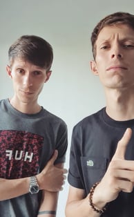 two men standing next to each other with their hands on their hipss