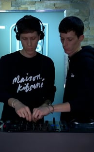 two men standing in front of a dj booth