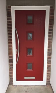 a new red composite front door with 4 squares of glass and curved long handle