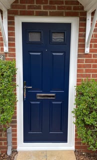 blue front door on red brick house with 2 panels of glass