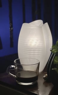 a vase with a vase of coffee and a vase with a plant in it