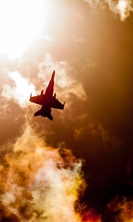 two jets are flying in the sky with clouds