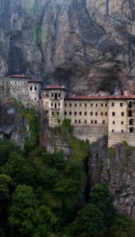 a mountaintopping with a large building in the background
