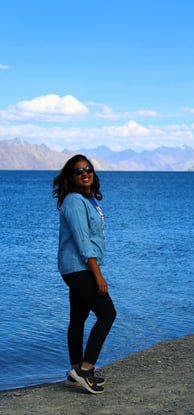 a woman standing on a side of lake