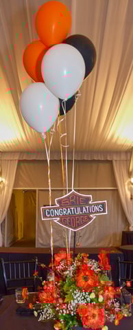 a motorcycle themed table setting with balloons and flowers