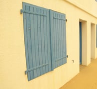 façade orange avec des volets en bois bleu 