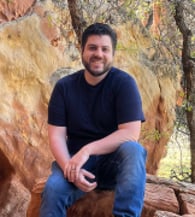 Christopher Carpenter sitting on a rock formation in the Utah mountains.