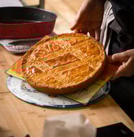 a person holding a cake with a pie