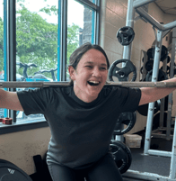 jessica kimball holding a squat bar and smiling