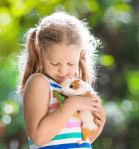 A young girl holding her pet guinea pig