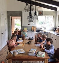 Children working on homeschool lessons at the kitchen table