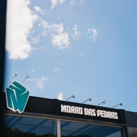 Fachada do CrossFit Morro das Pedras em Florianópolis com céu azul e destaque para o logo no sul da Ilha.