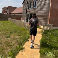 deanos removals worker carrying a box into a house in worcester