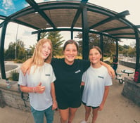 three girls hugging ad smiling