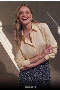 a woman in a yellow shirt and black skirt