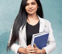 "Teacher standing with books in hand, ready to guide students in their learning."