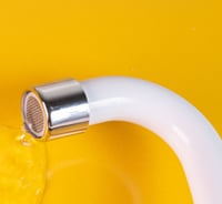 robinet blanc qui fuit sur fond jaune