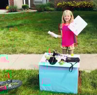 baylor holding an open sign for her yard sale