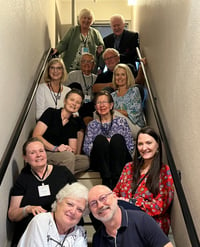 twelve Telelaget members sit in a stairwell