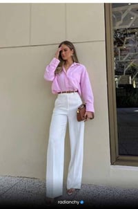 a woman in a pink shirt and white pants