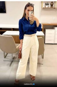 a woman in a blue shirt and white pants
