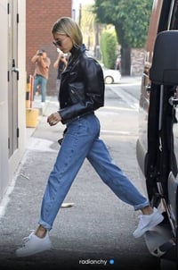 a woman in a black leather jacket and jeans
